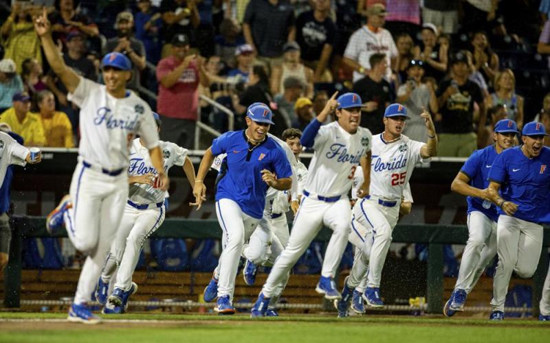 The Florida dugout runs onto the field while celebrating their walkoff win against Virginia in their College World Series opener on Friday Omaha, Neb. (JOHN PETERSON/Associated Press)