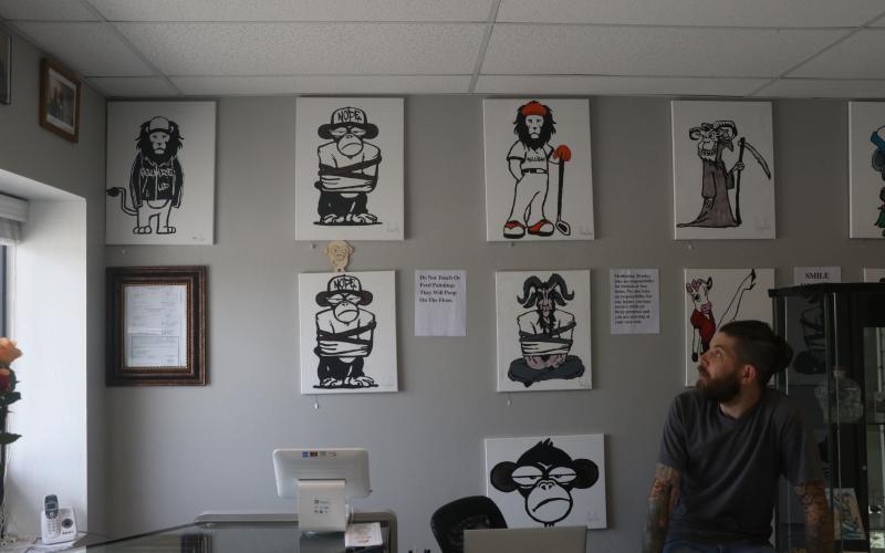 Meditating Monkey Art Emporium owner Gary Rife explains the concept behind the animal artwork Friday. (MORGAN MCMULLEN/Lake City Reporter)