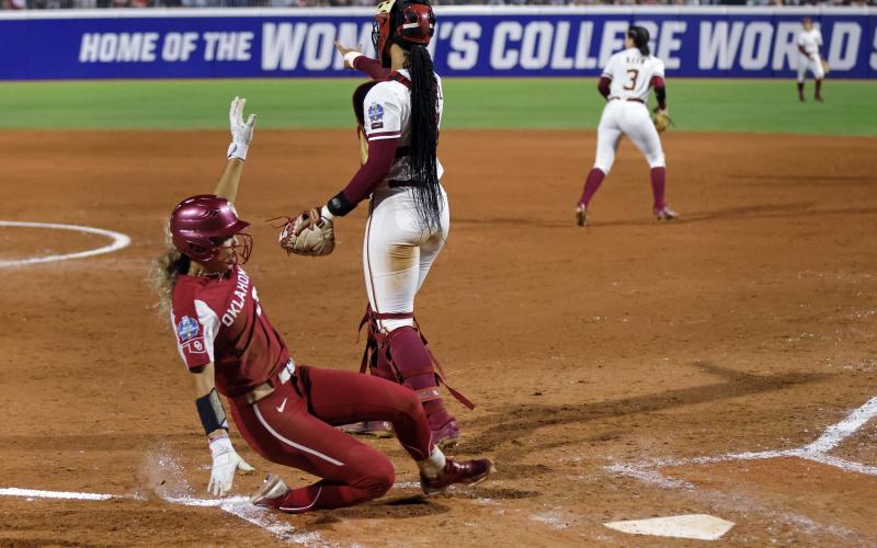 Oklahoma's Jayda Coleman slides into home plate to score past Florida State catcher Michaela Edenfield during the fifth inning of Game 1 of the Women's College World Series championship series on Wednesday in Oklahoma City. (NATE BILLINGS/Associated Press)