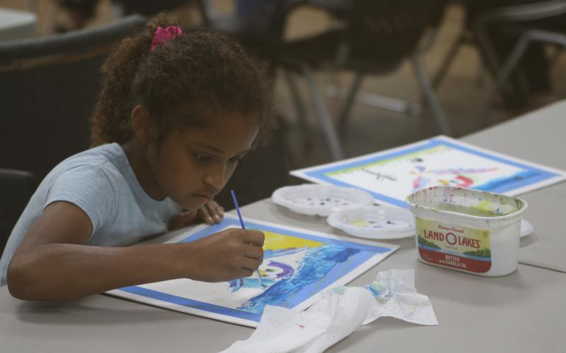 Aaliyah Singh concentrates on her watercolor painting Friday during the Young Da Vinci Art Camp at the Gateway Art Gallery. (JAMIE WACHTER/Lake City Reporter)