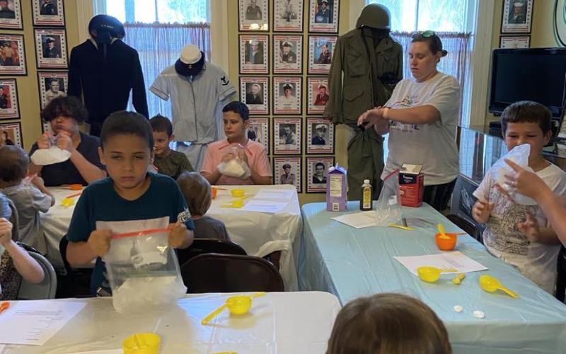 Landon Ream, left, is among the children that learned how to make ice cream in a bag Thursday at the Lake City-Columbia County Historical Museum. (COURTESY)