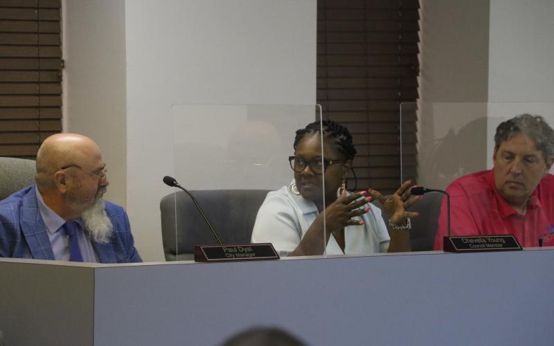 Councilwoman Chevella Young (middle) speaks to City Manager Paul Dyal as Councilman Todd Sampson listens during Monday’s Lake City Council meeting. (MORGAN MCMULLEN/Lake City Reporter)