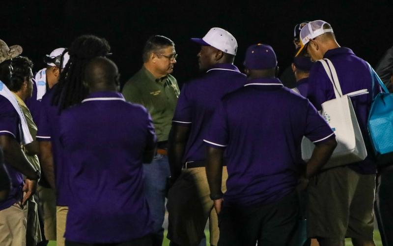 Columbia County Sheriff Mark Hunter talks will Columbia High and Buchholz High officials Friday night at Tiger Stadium. The season opener was postponed until Saturday night following two armed men climbing a fence at Tiger Stadium. (BRENT KUYKENDALL/Lake City Reporter)