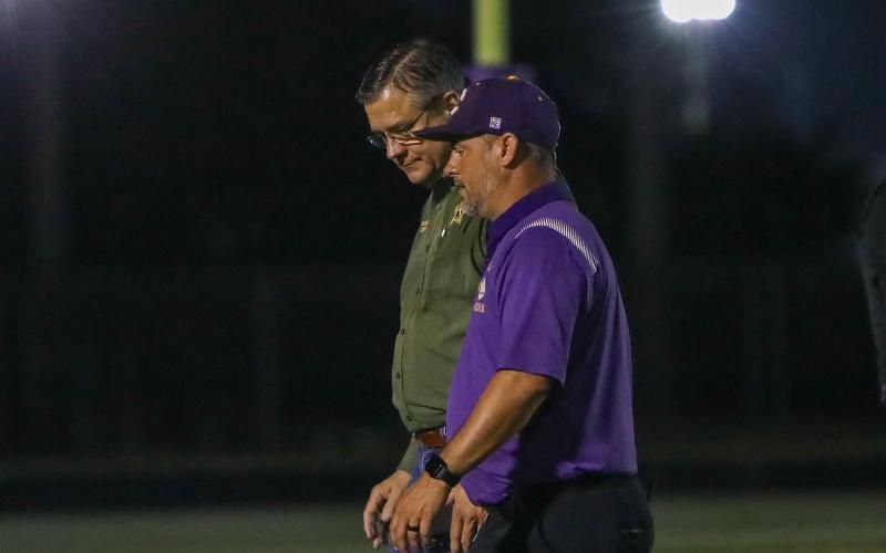 Columbia High Principal Trey Hosford talks with Columbia County Sheriff Mark Hunter at Tiger Stadium on Friday night after two armed teens climbed a fence attempting to get in. (BRENT KUYKENDALL/Lake City Reporter)