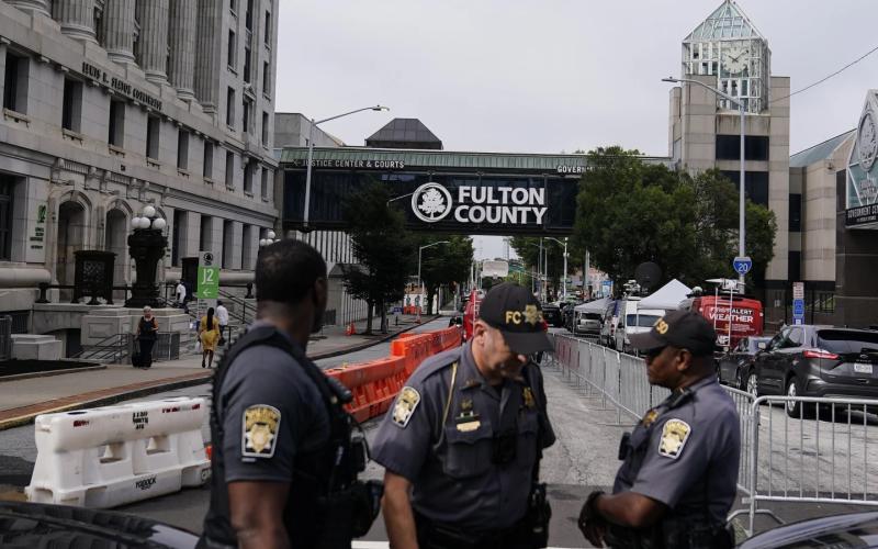 Authorities stand near barricades at the Fulton County courthouse Monday in Atlanta. The sheriff’s office is implementing various security measures ahead of a possible indictment against former President Donald Trump. (BRYNN ANDERSON/Associated Press)