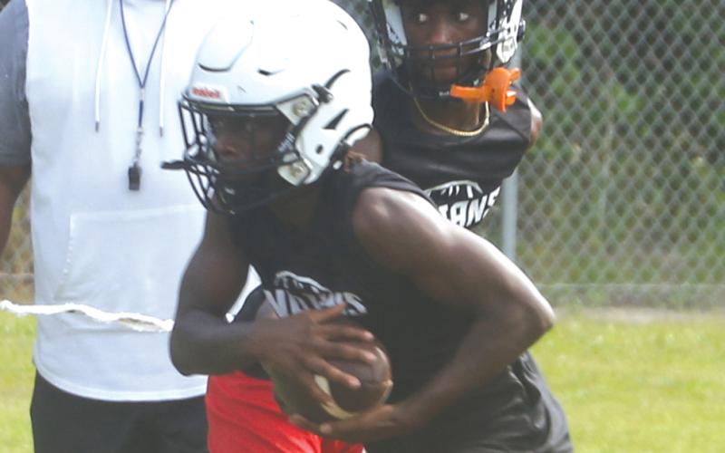 Fort White receiver Najeeb Smith takes a handoff from quarterback Jayden Jackson during practice on July 31. (MORGAN MCMULLEN/Lake City Reporter)