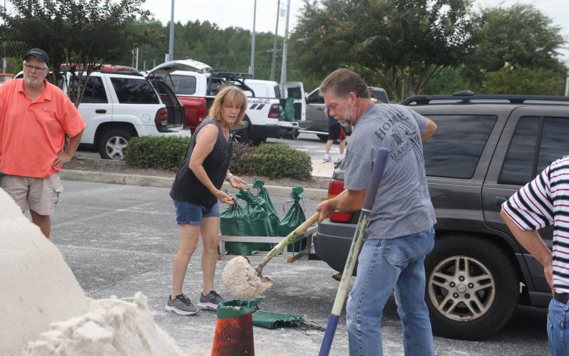 Elizabeth and Darryl Boyette prepare and load sandbags at the Southside Sports Complex Tuesday morning ahead of Hurricane Idalia’s expected landfall Wednesday morning. (MORGAN MCMULLEN/Lake City Reporter)