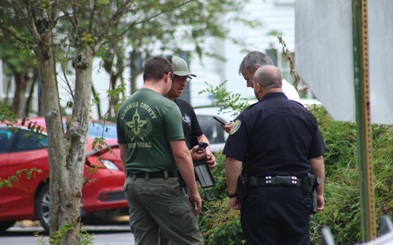 Members of the Alachua County Bomb Squad and Lake City Police Department look at the suspicious device found in the Quality Inn on Thursday morning. (JAMIE WACHTER/Lake City Reporter)