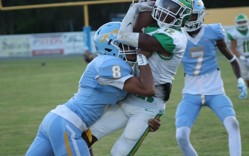Suwannee wide receiver Daijuan Perkins catches a pass Friday night as a Chiefland defensive back delivers a hit at Pridgeon Stadium. (JAMIE WACHTER/Lake City Reporter)