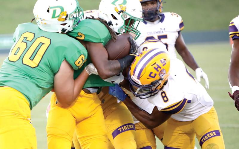 DeLand running back Ladamion Bletcher tries to power through Columbia defenders, including Markeyon Moore (8) on Friday night at Spec Martin Memorial Stadium. (BRENT KUYKENDALL/Lake City Reporter)