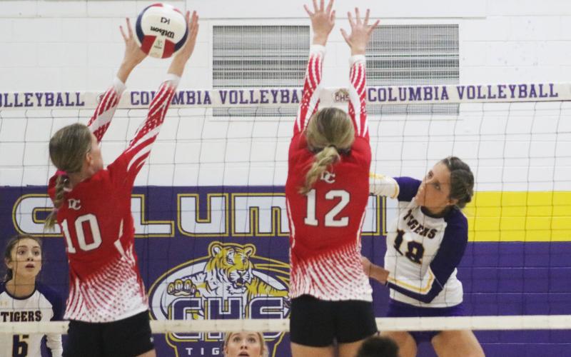 Columbia outside hitter Autumn Jones sends a shot past Dixie County’s Hailey Moody (10) and Kailey Edmonds (12) on Wednesday night. (JORDAN KROEGER/Lake City Reporter)