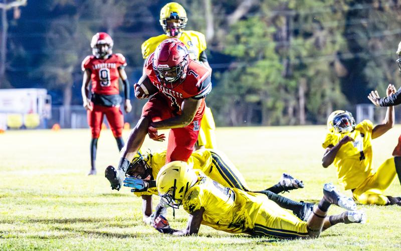 Lafayette running back Jamarien Ervin leaps over a Zarephath Academy defender on Friday. (JACK HOWDESHELL/Special to the Reporter)