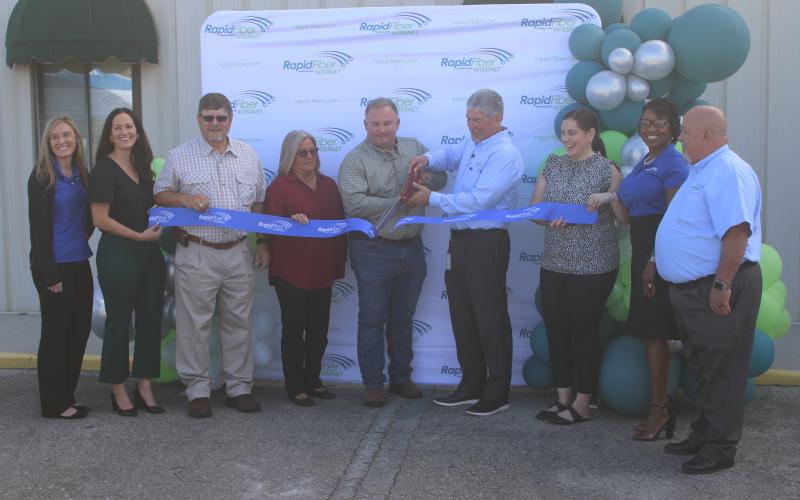 Mike McWaters, the president and CEO of Suwannee Valley Electric Cooperative and chairman of the board of managers for Rapid Fiber Internet (middle right), and Tyler Putnal, the president of SVEC’s board of trustees, cut the ribbon Monday for the launch of Rapid Fiber Internet, which went live in its first zone Sept. 18. (JAMIE WACHTER/Lake City Reporter)