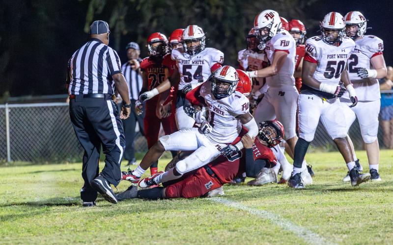 Lafayette defensive back Tywan Williamson (9) tackles Fort White running back Dakota Fisher (1) last Friday. (JACK HOWDESHELL/Special to the Reporter)