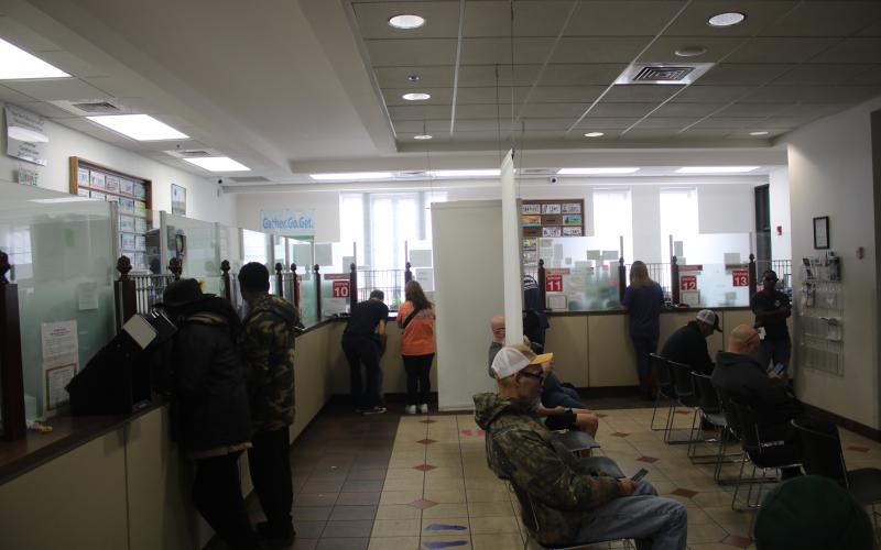 Several stations at the Columbia County Tax Collector Office serve customers as other patrons await their turn. The office served more than 600 customers on Friday, the final business day of the year. (TONY BRITT/Lake City Reporter)