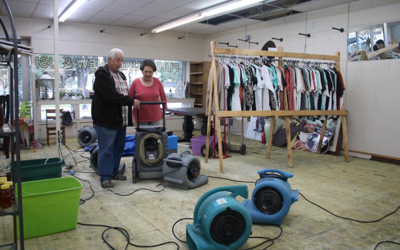 Buck Strickland (from left) and Linda Odom, owners of Furnishings on Marion, look over various blowers that were put in the store to dry its interior after it received extensive water damage. (TONY BRITT/Lake City Reporter)