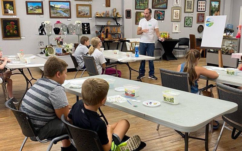 Jeffrey Moore (standing), a Gateway Art Gallery member, instructs Junior Youth Art League class  students during a recent session. (COURTESY)