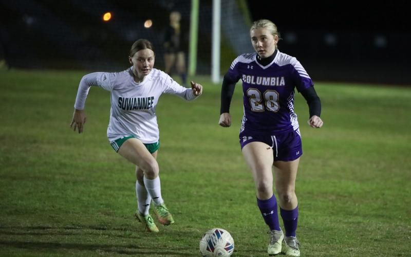 Columbia's Kyndall Norris dribbles up the field as Suwannee's Whitton Musgore gives chase on Thursday night. (BRENT KUYKENDALL/Lake City Reporter)