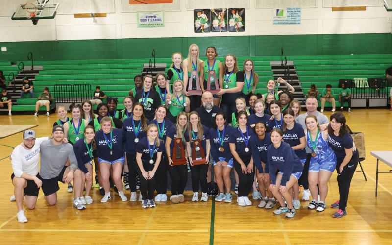 District 4-1A champion Suwannee and district runner-up Maclay pose with their district trophies on Friday. (PAUL BUCHANAN/Special to the Reporter)