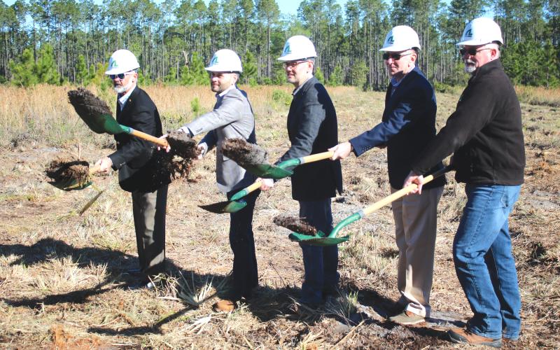 AgroLiquid adminstrators David Gilliam (from left), Gerrit Bancroft, Nick Bancroft, Alan Kennedy and Todd Cressman toss dirt from their shovels during  Tuesday morning’s groundbreaking ceremony for the new AgroLiquid plant at the North Florida Mega Industrial Park. (TONY BRITT/Lake City Reporter)