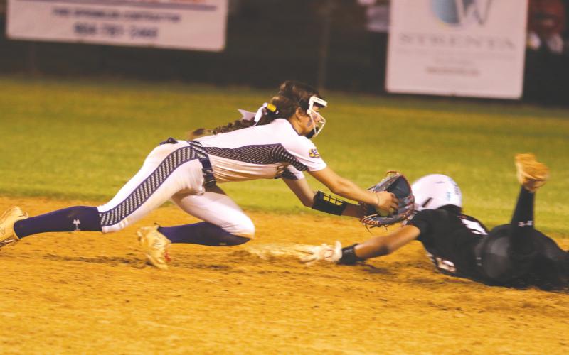 Columbia shortstop Lillyenne Mayhew applies a late tag to Baldwin shortstop Amiyah Jones during the Tigers’ 9-0 loss on Friday. (MORGAN MCMULLEN/Lake City Reporter)
