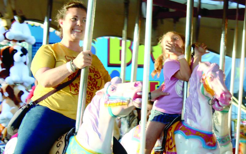 A mother and daughter enjoy a ride at a previous year’s Suwannee County Fair. The 109th annual fair begins its nine-day run Friday at the Suwannee County Fairgrounds. (FILE)