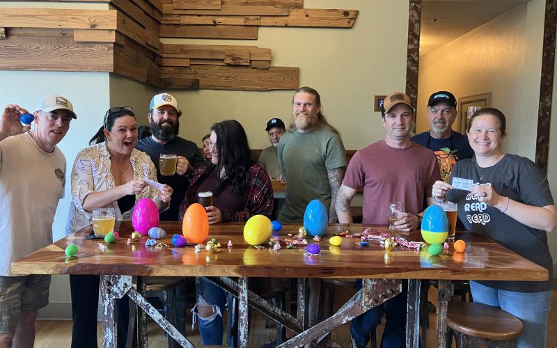 The team of the Chief’s Council Members — Halpatter’s Mug Club — assemble Easter eggs for Saturday’s hunt. Douglas Weisberg (from left), Kristen Jones, Tim Jones, Lindsey Strickland, Casey Woods, Ryan Scuglia, Glenn Rasmussen and Heidi Scuglia put together roughly 3,000 eggs filled with candy and local coupons for the event. (COURTESY)