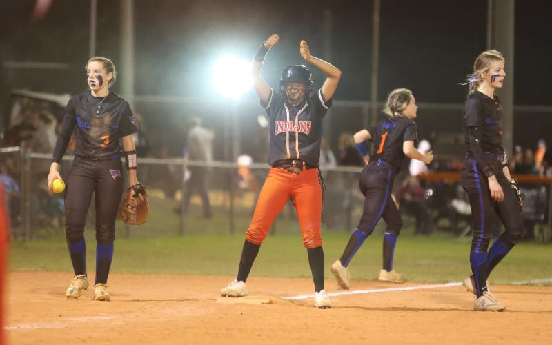 Fort White’s Jermauni Byrd celebrates on third base between Branford shortstop Cloey Criggall and third baseman Madyson Sikes on Friday. (PAUL BUCHANAN/Special to the City Reporter)