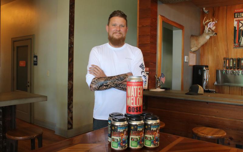 Jonny Frazier, Halpatter Brewing Company head brewer and co-owner, stands with the brewery’s Watermelon Gose and Blue Raspberry Lemonade Punch Out, two of its award-winning brews in the Untappd Community Awards. (TONY BRITT/Lake City Reporter)