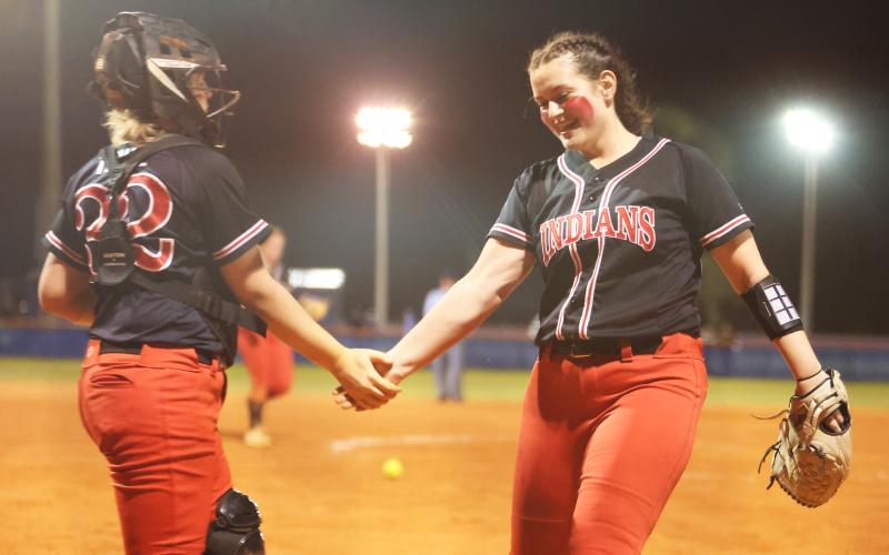 Fort White catcher Chloe Kirby (left) shakes hands with pitcher Kadence Compton (right) after the final out of the Indians’ win over Branford on March 1. (PAUL BUCHANAN/Special to the Reporter)