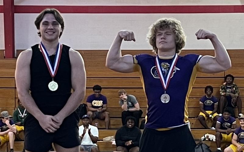Columbia lifters Tyson Yaxley (left) and Garrett Shipley (right) celebrate on the podium after placing first and second at the District 3-2A meet on Thursday. (COURTESY)
