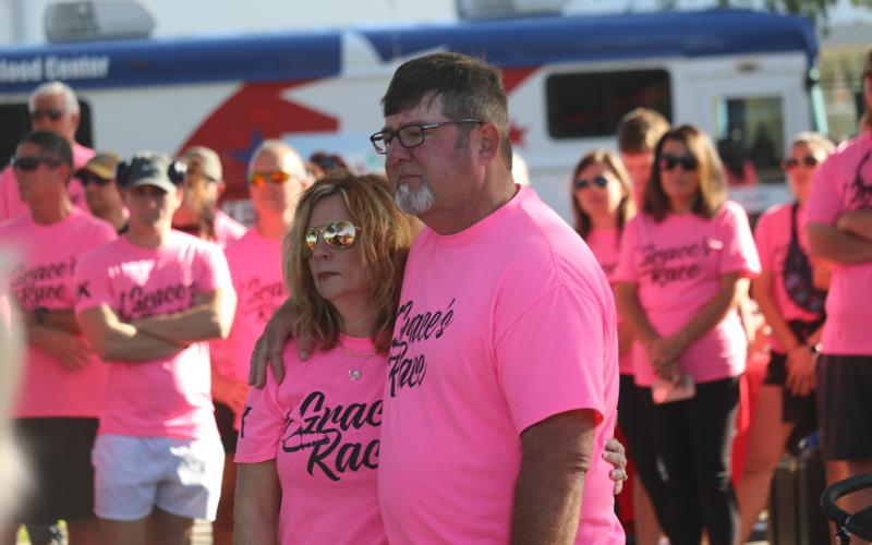 Grace Duncan’s parents, Burt and Cissy, listen during a prayer prior to the start of last year’s Grace’s Race 5K run/walk. The fourth annual event, which is held in Duncan’s memory, is set for Saturday. (FILE)