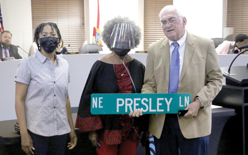 Lake City Mayor Stephen Witt holds up the NE Presley Lane sign next to Bernice Presley (middle) and Sharyn Presley (left) after the Lake City Council agreed to rename NE Railroad Street in honor of the Presley family. (MORGAN MCMULLEN/Lake City Reporter)