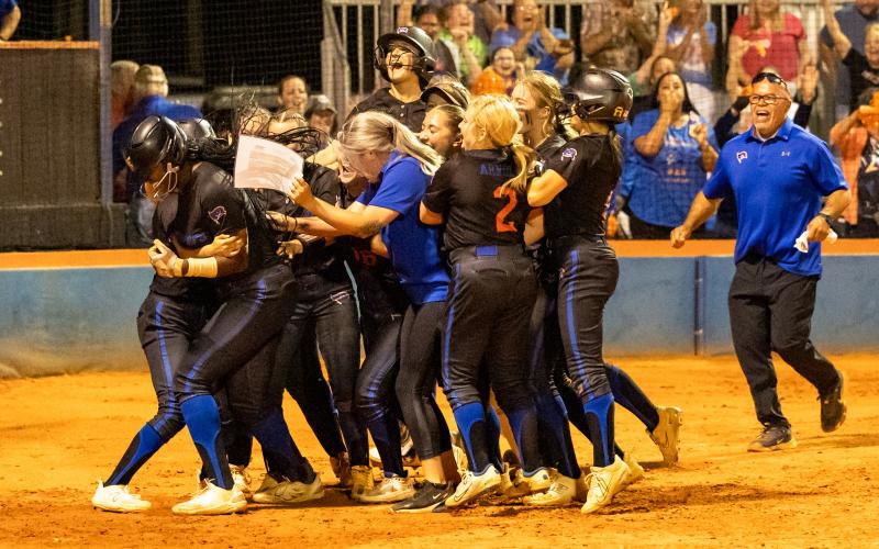 Branford's softball team celebrates with Mallory Blue at home plate after she scored the game-winning run in extra innings to defeat Aucilla Christian in the Region 3-1A semifinals on Thursday. (JACK HOWDESHELL/Special to the Reporter)